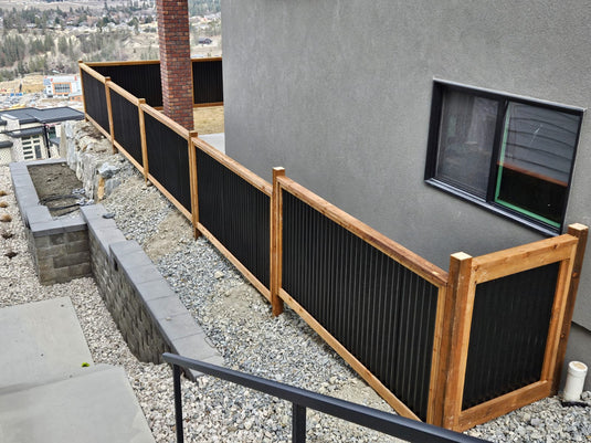 HOA-approved privacy fence with black corrugated steel panels and wood frame.