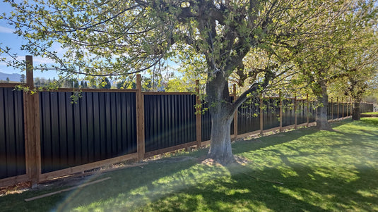 Deep groove metal fence panel in urban residential yard.