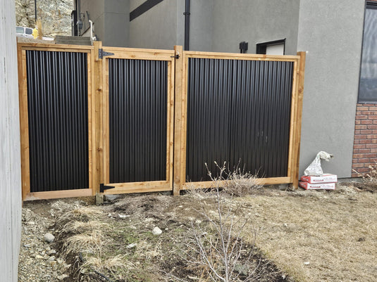 Corrugated black steel fence panel with matching gate.
