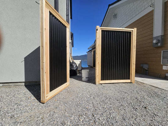 Modern metal fence gate installed with corrugated steel panels.