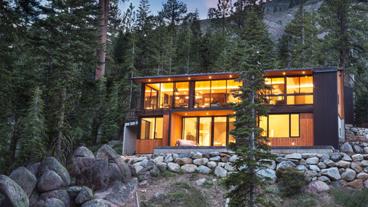 Modern cabin with metal siding mixed with wood and glass accents.