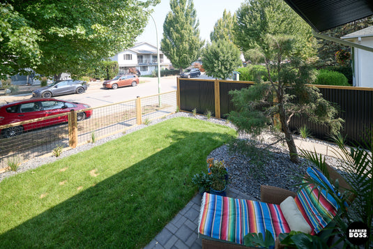 Serene backyard with hybrid fencing installed along the side and front of property.