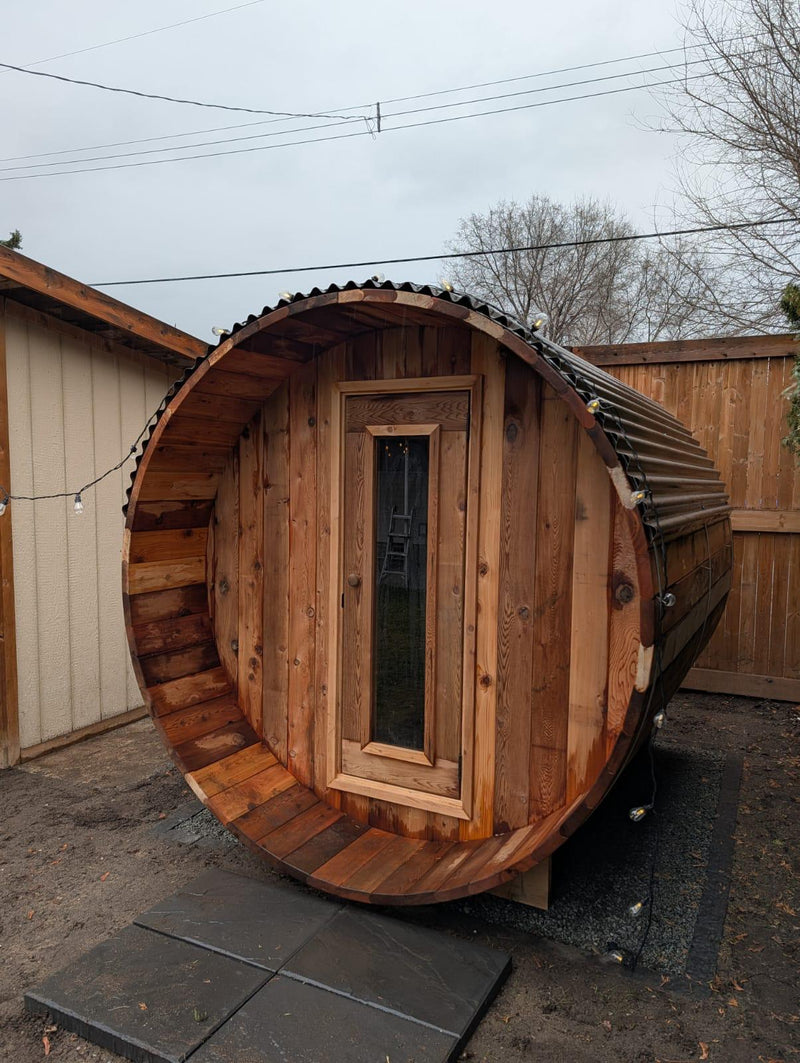 Load image into Gallery viewer, Wooden barrel-shaped sauna with a door in an outdoor setting
