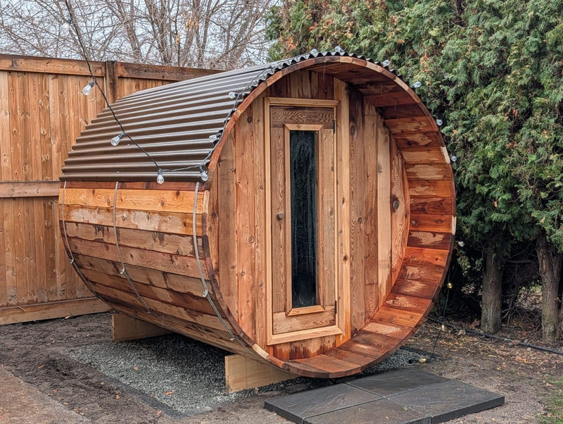 Load image into Gallery viewer, Wooden barrel-shaped structure with corrugated metal roof in an outdoor setting.
